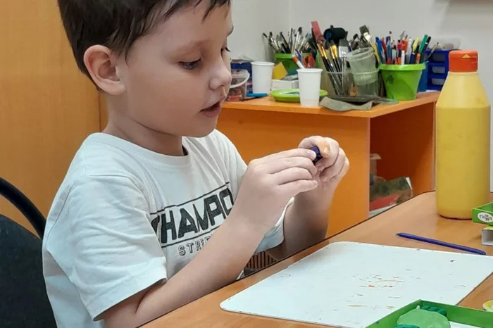 Мальчик лепит из пластилина