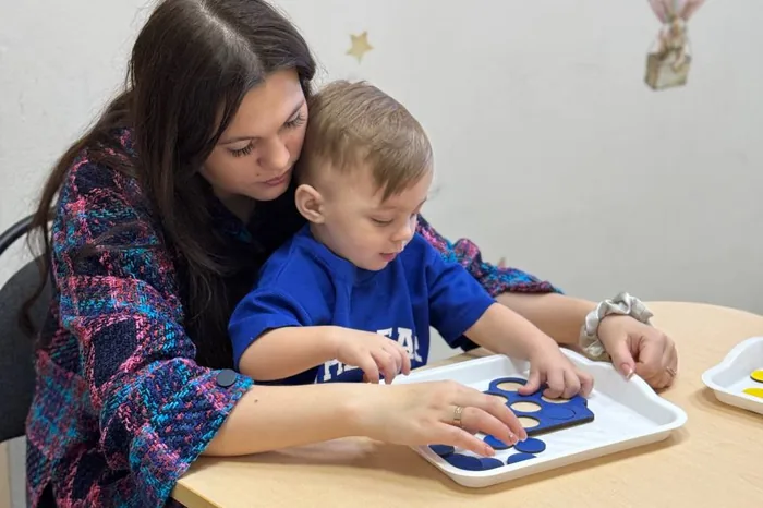 Педагог и малыш за развивающим занятием
